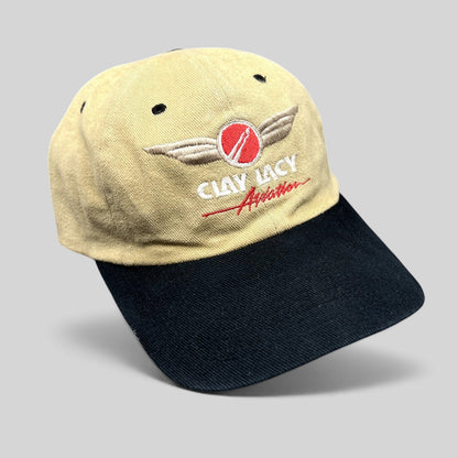 Raree Finds vintage Clay Lacy Aviation strapback hat with a tan cotton crown, black brim, and embroidered logo.