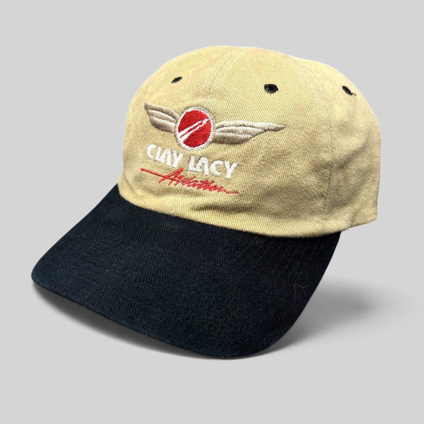 Raree Finds vintage Clay Lacy Aviation strapback hat with a tan cotton crown, black brim, and embroidered logo.