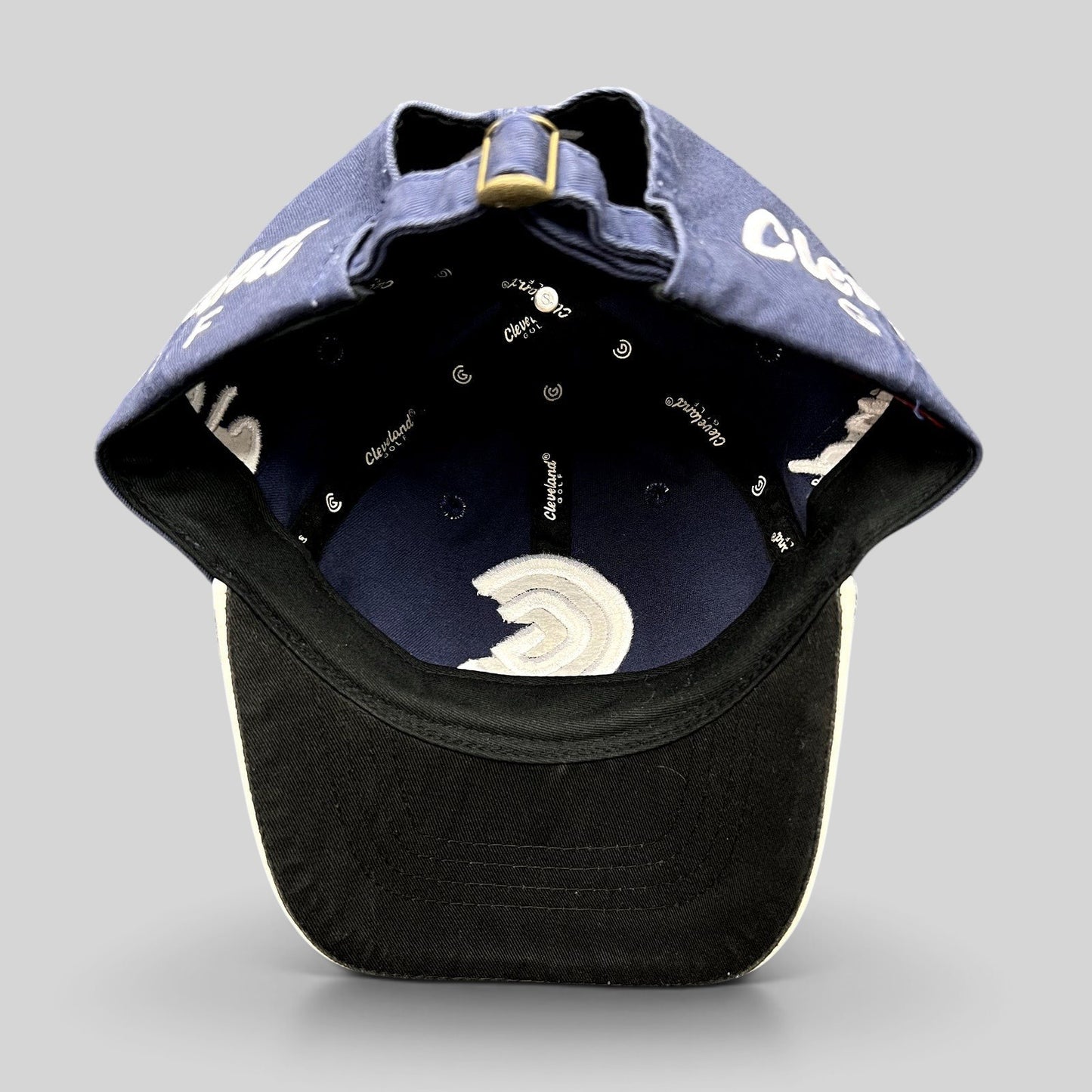 Raree Finds navy blue Cleveland Golf strapback hat interior view showing branded lining and adjustable brass buckle
