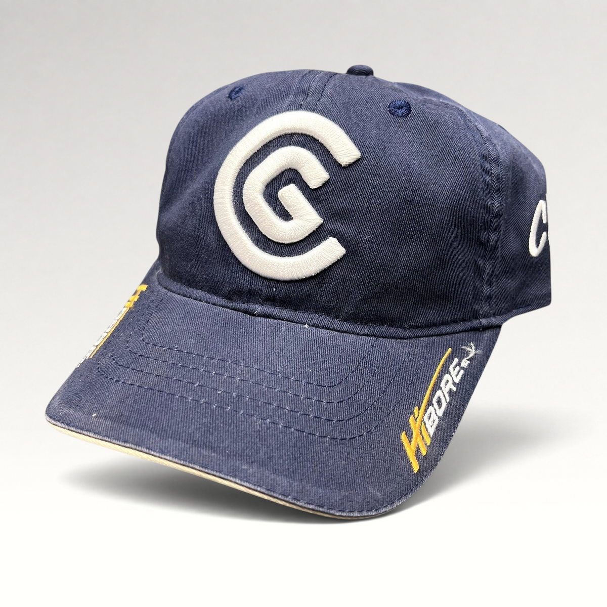 Raree Finds navy blue cotton twill Cleveland Golf strapback hat with raised white CG logo and HiBore brim embroidery.