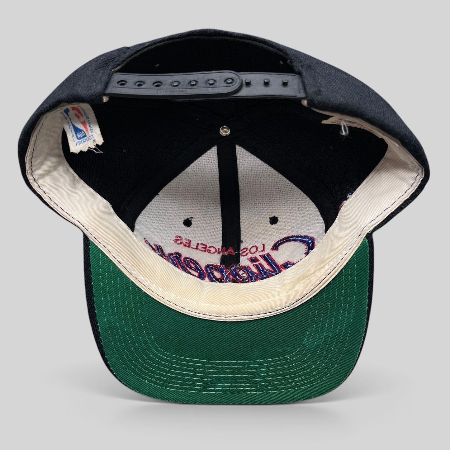 Raree Finds vintage Sports Specialties LA Clippers NBA snapback hat showing the green undervisor and interior tags.