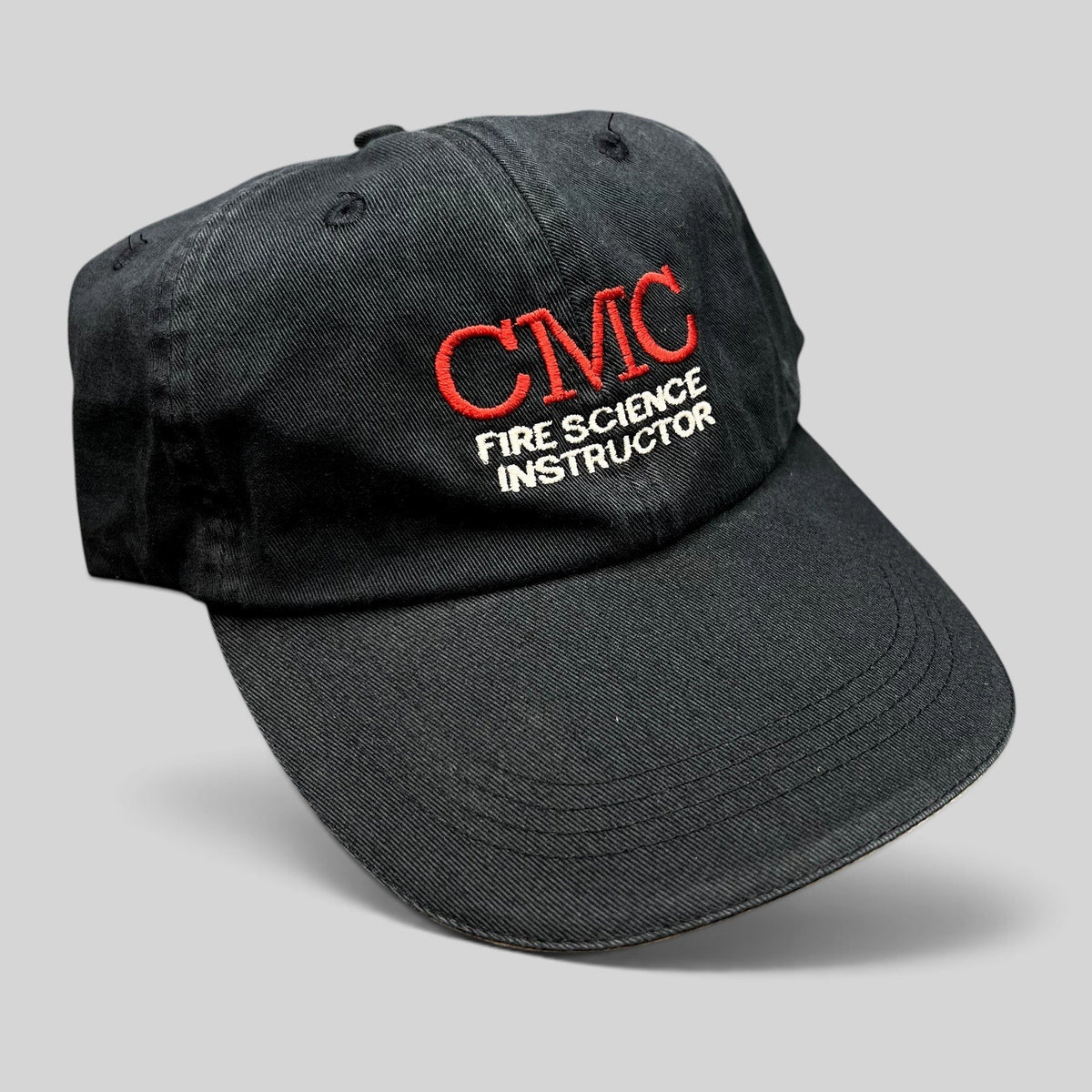 Raree Finds black cotton strapback hat with CMC Fire Science Instructor embroidery in red and white thread.