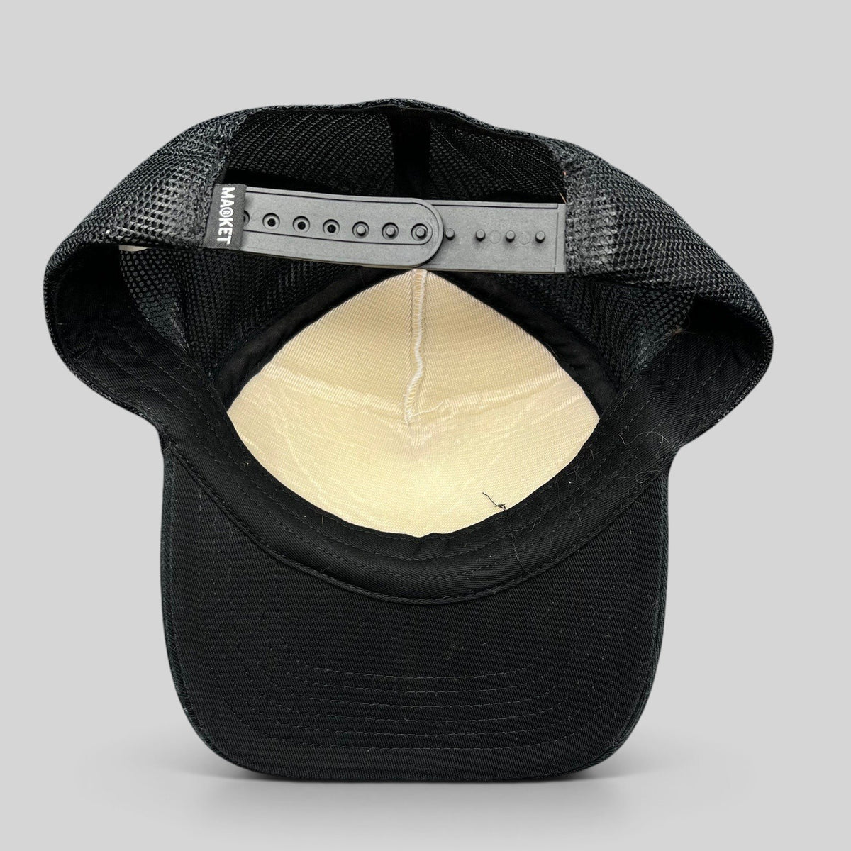 Raree Finds Coachella x Market black and white trucker hat showing the interior mesh lining and snapback closure