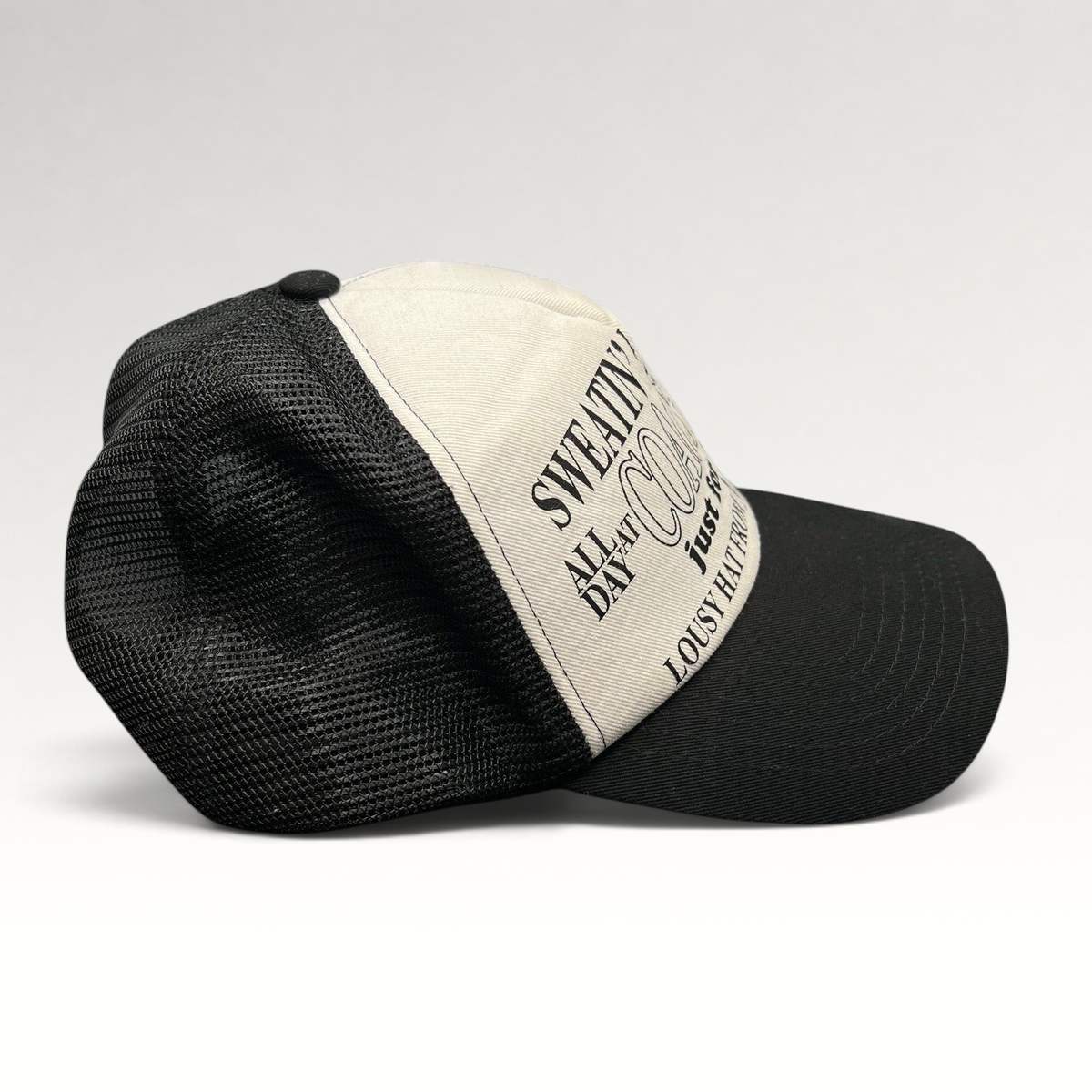 Raree Finds Coachella x Market black and white trucker hat with graphic text on the foam front and mesh back.