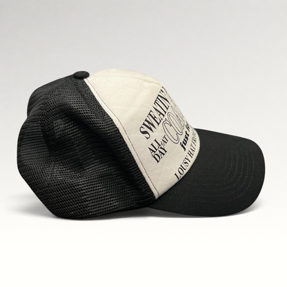 Raree Finds Coachella x Market black and white trucker hat with graphic text on the foam front and mesh back.