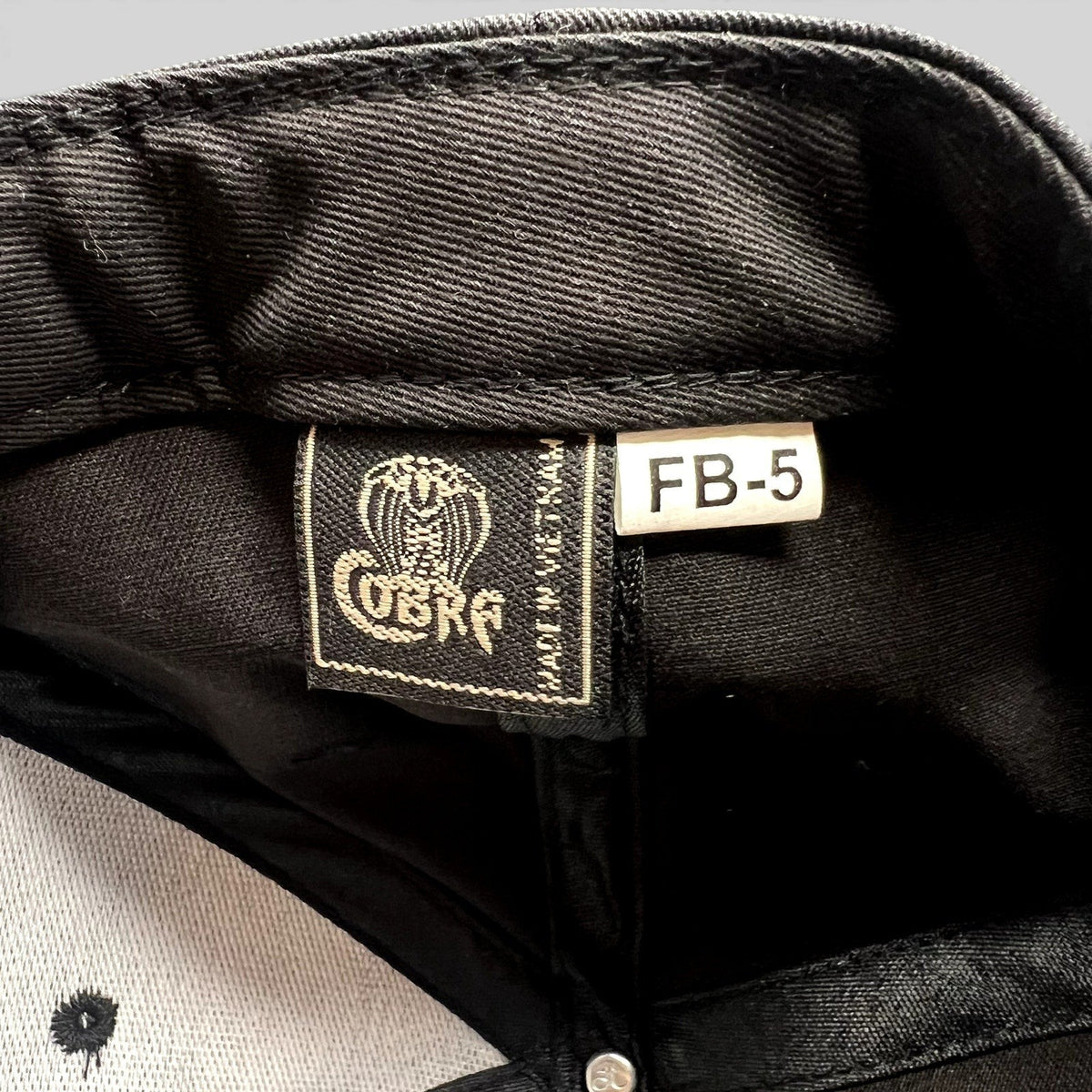 Raree Finds Prince St Pizza snapback interior showing the Cobra Cap brand label and black fabric construction