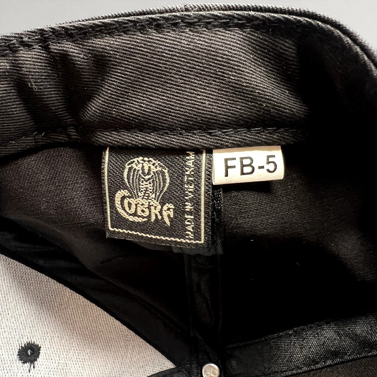 Raree Finds Prince St Pizza snapback interior showing the Cobra Cap brand label and black fabric construction
