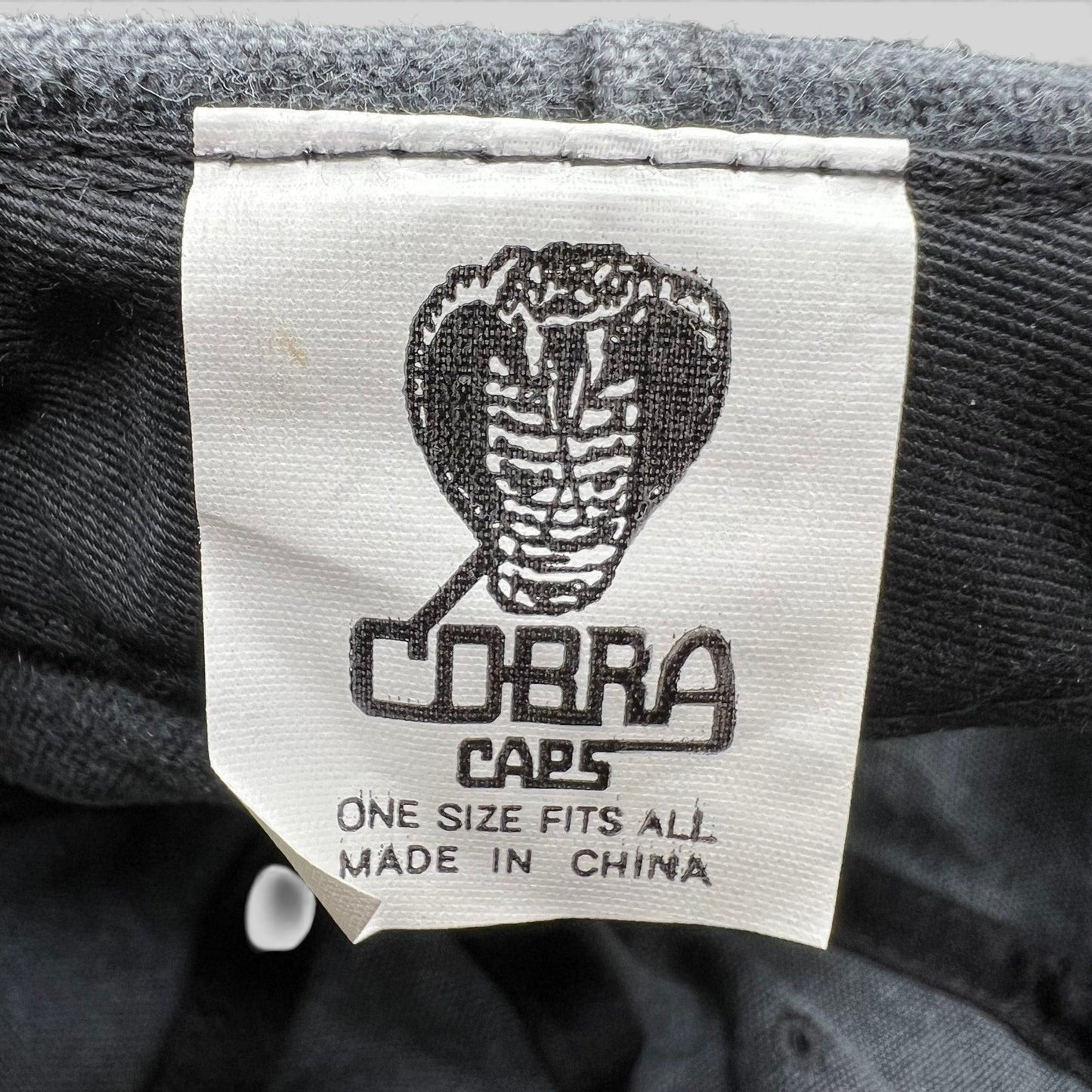 Raree Finds vintage 1998 Cobra Caps hat interior label showing brand logo and manufacturing details