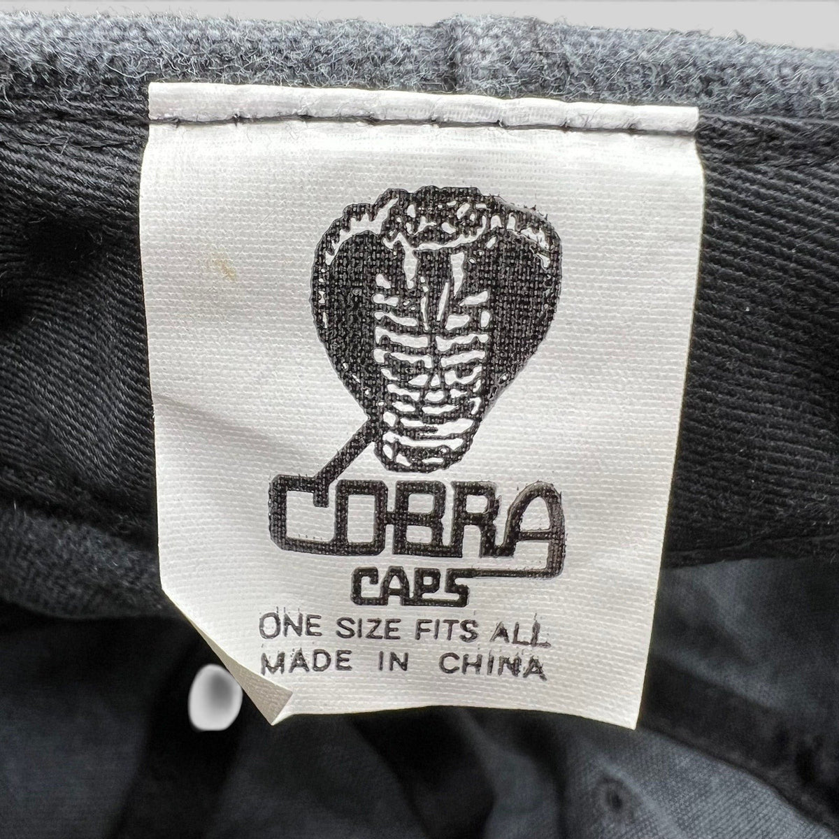 Raree Finds vintage 1998 Cobra Caps hat interior label showing brand logo and manufacturing details