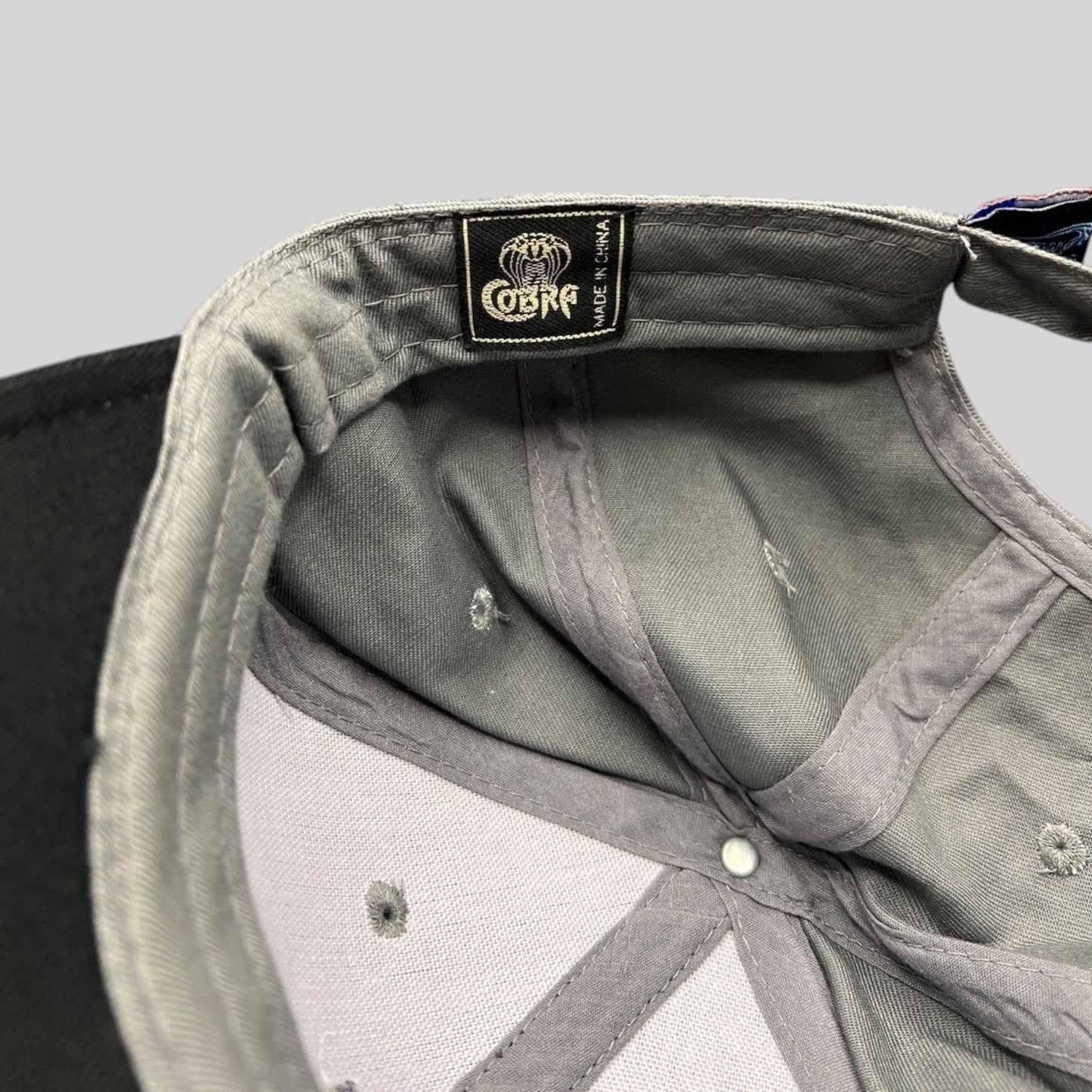 Raree Finds Cobra Headwear interior tag on a black and gray structured Toyota Tundra promotional cap