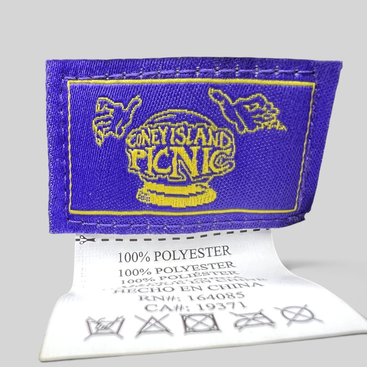 Raree Finds Coney Island Picnic purple and yellow embroidered brand label and polyester care tag