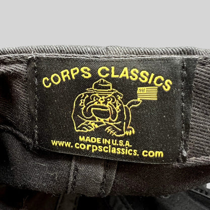 Raree Finds Corps Classics black fabric hat label with yellow embroidered bulldog mascot and American flag logo