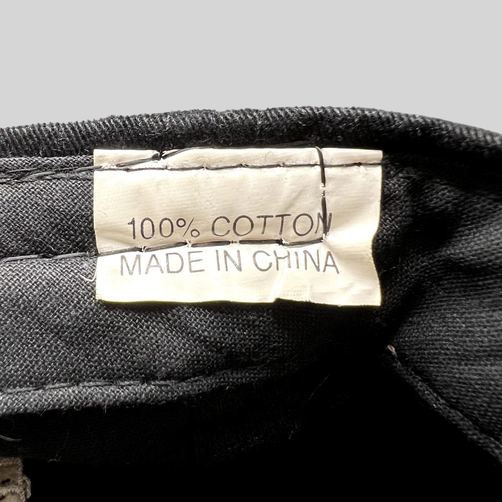 Raree Finds vintage hat interior tag showing 100% cotton material and made in China label on black fabric