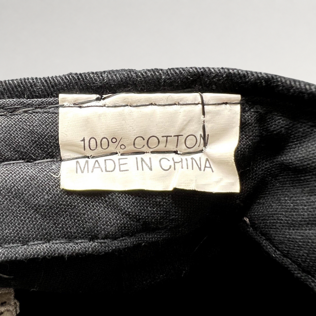 Raree Finds vintage hat interior tag showing 100% cotton material and made in China label on black fabric