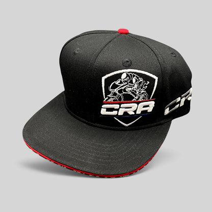 Raree Finds vintage black snapback hat with embroidered CRA motorcycle racing logo and red, white, and blue accents.