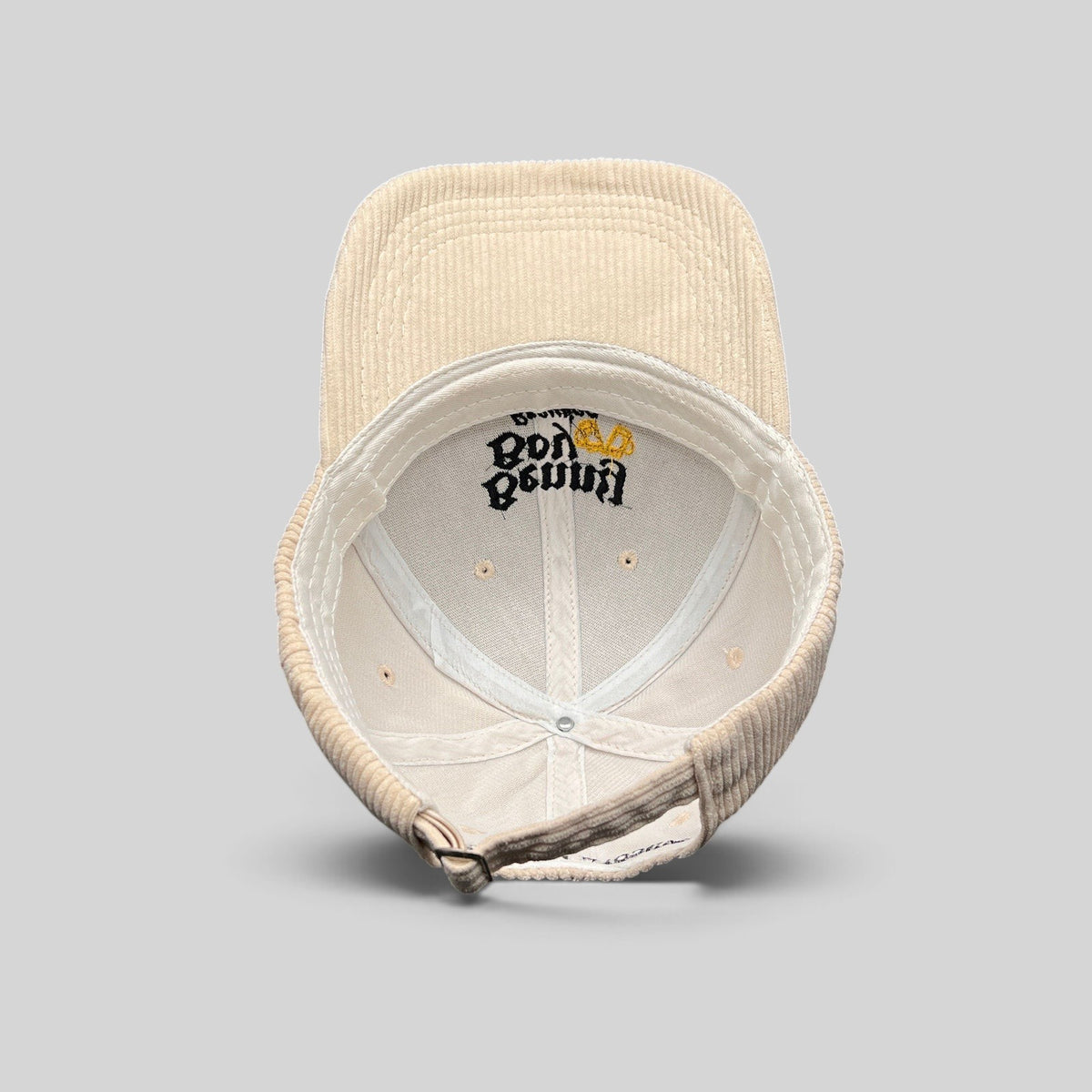 Raree Finds Benny Boy Brewing cream corduroy strapback hat showing the interior crown and adjustable metal buckle.