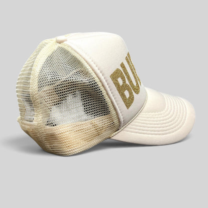 Raree Finds cream and off-white trucker hat with gold glitter BUBBLY lettering and breathable mesh back panel.