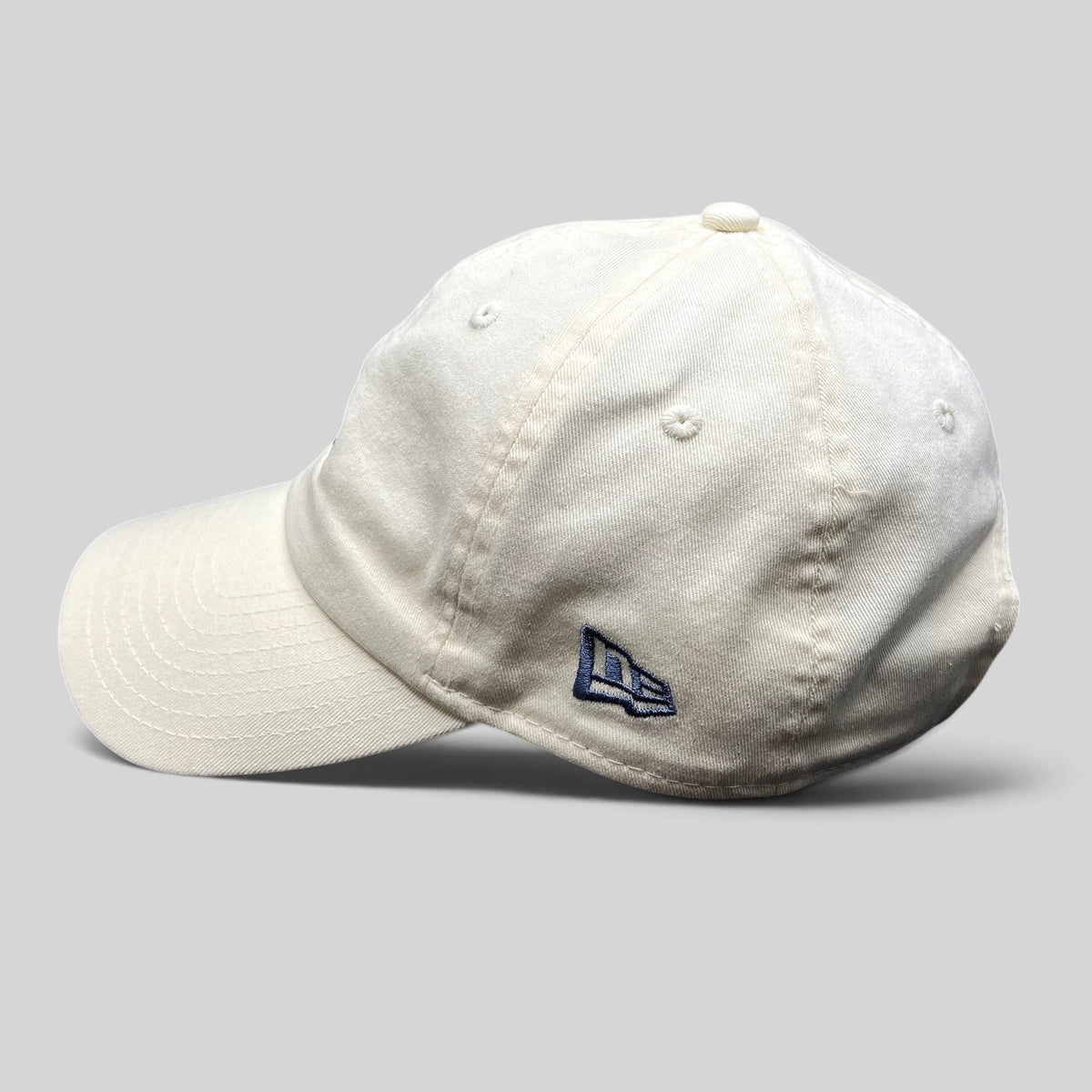 Raree Finds cream New Era strapback hat with side embroidered logo, unstructured cotton crown, and curved brim.