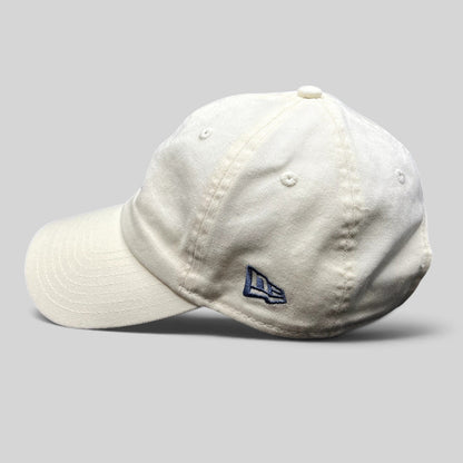 Raree Finds cream New Era strapback hat with side embroidered logo, unstructured cotton crown, and curved brim.