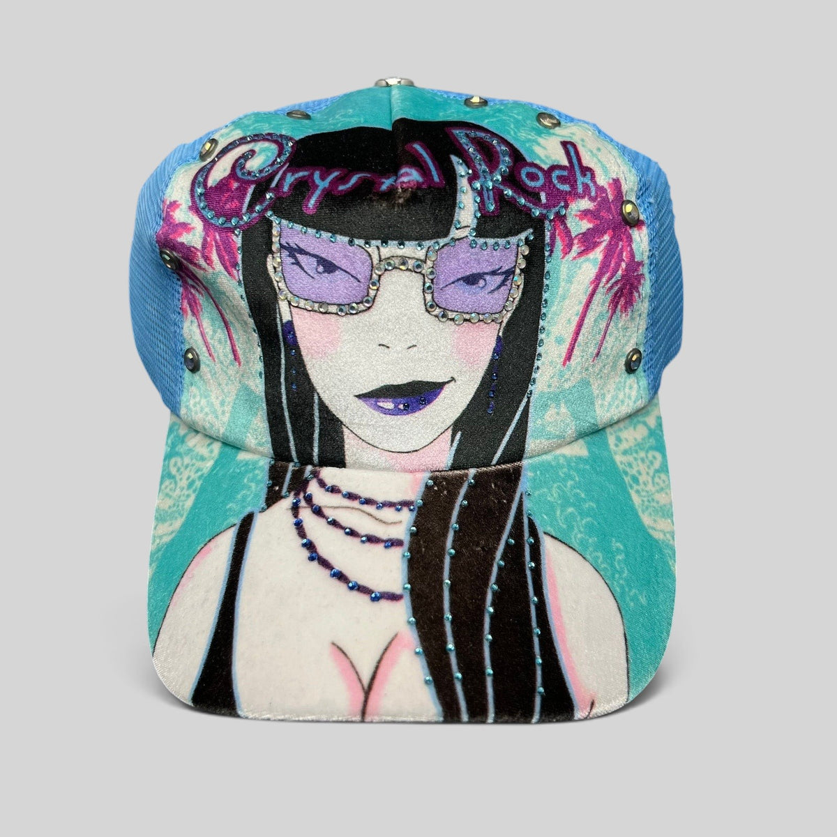 Raree Finds Crystal Rock by Christian Audigier teal trucker hat with rhinestone graphic and metallic stud accents.