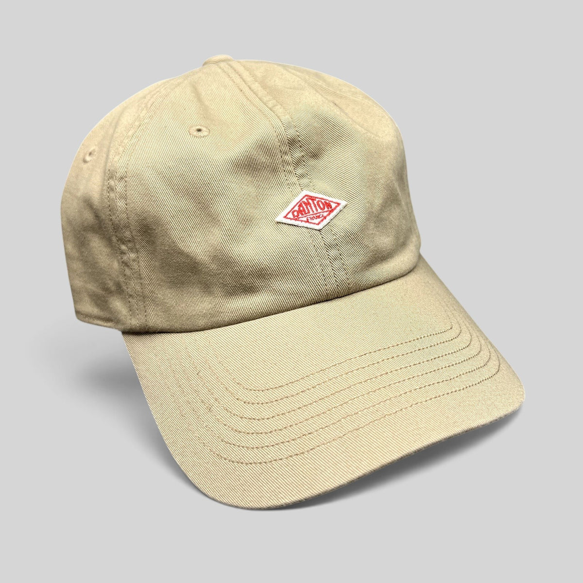 Raree Finds Danton khaki cotton twill strapback hat with an embroidered red diamond logo on a six-panel cap.