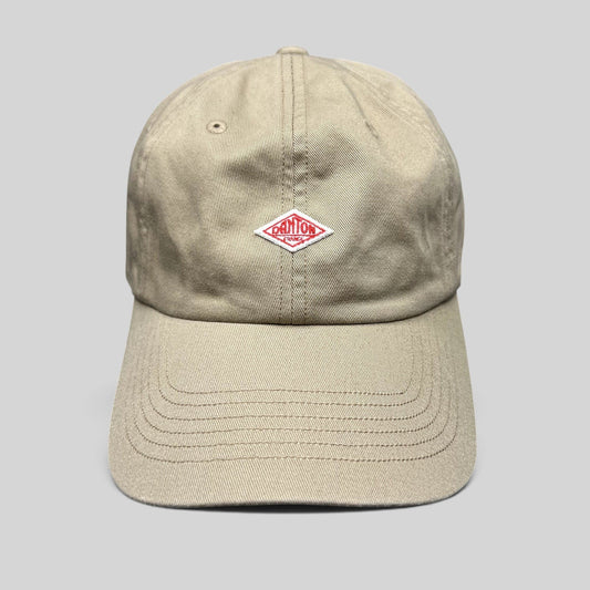 Raree Finds Danton khaki cotton twill strapback hat featuring an embroidered red diamond logo on a six-panel cap.