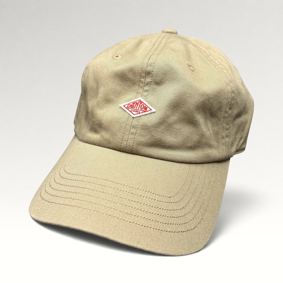Raree Finds Danton khaki cotton twill strapback hat with a signature red diamond logo on the front