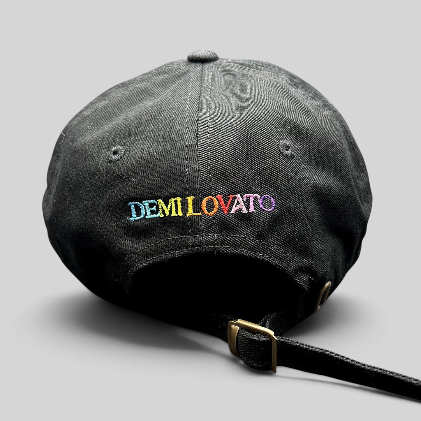 Raree Finds black cotton dad hat with colorful rainbow DEMI LOVATO embroidery on the back and metal buckle strap.