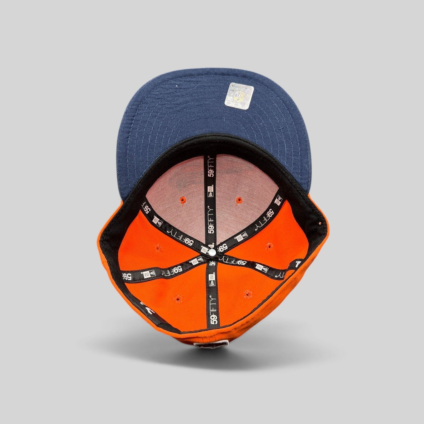 Raree Finds New Era Denver Broncos fitted hat interior showing orange crown, navy brim, and branded taping.