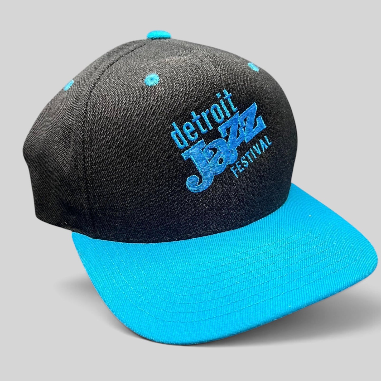Raree Finds vintage Detroit Jazz Festival snapback hat with a black crown, teal brim, and blue embroidered lettering.