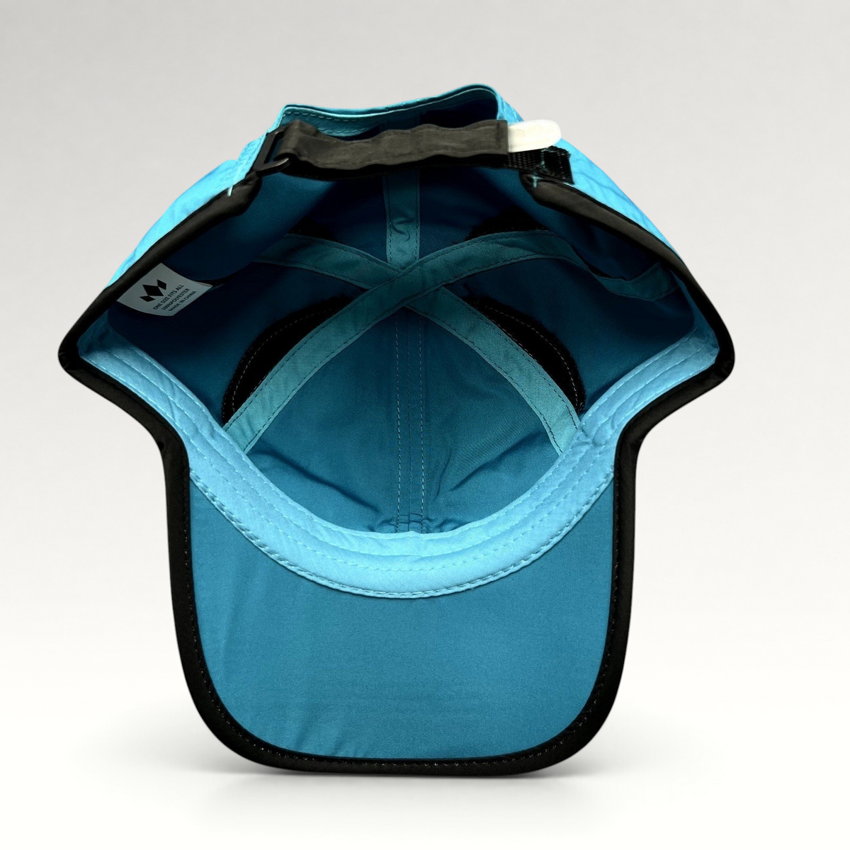 Raree Finds Diadem performance running hat in blue polyester with black trim, showing the interior strapback closure.