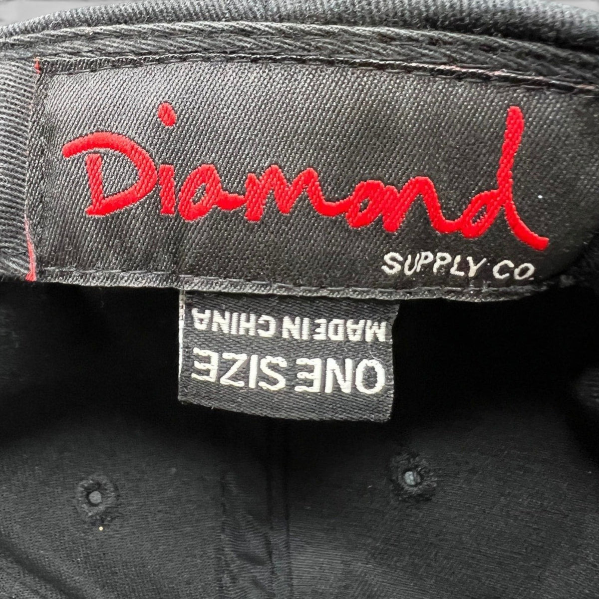 Raree Finds vintage Diamond Supply Co. snapback hat interior tag with red logo embroidery on black cotton fabric