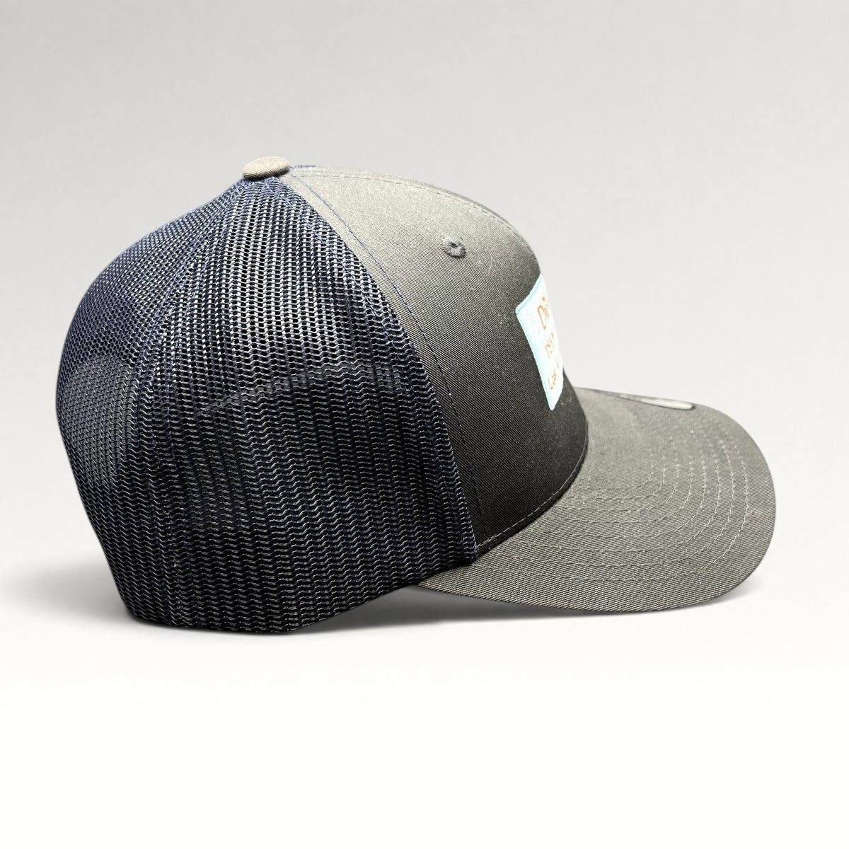 Raree Finds Diller Teen Fellows charcoal and navy Yupoong Classics trucker snapback hat with side profile view