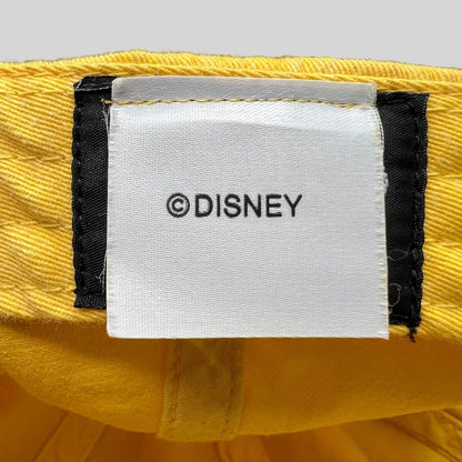 Raree Finds Disney VoluntEARS hat interior tag with white fabric and black Disney branding on a yellow cotton crown