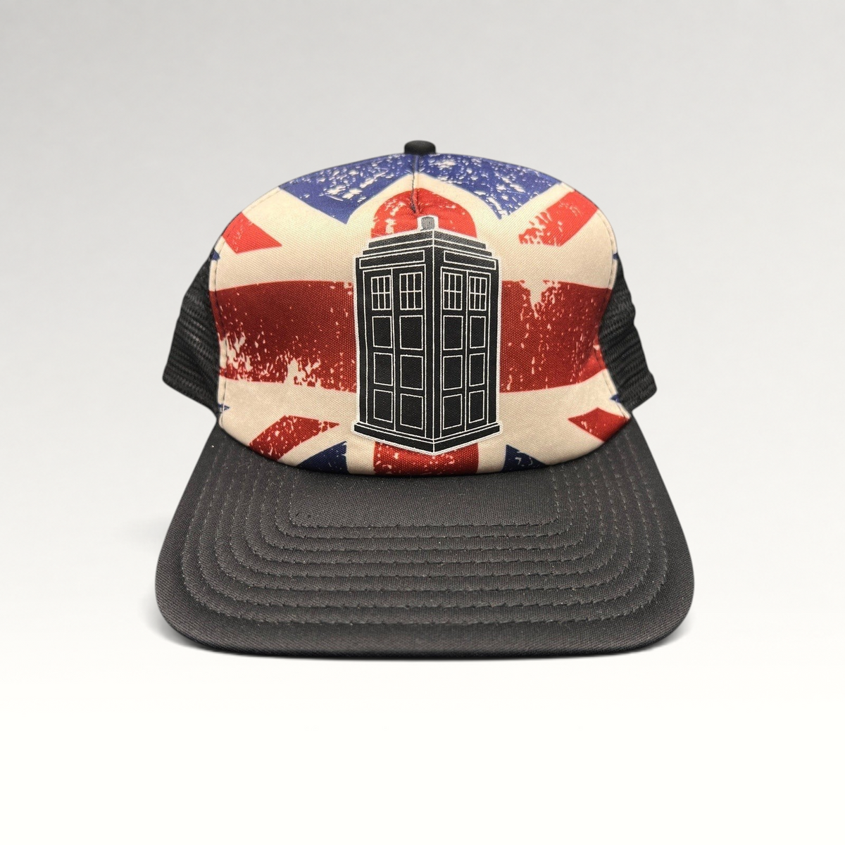 Raree Finds Doctor Who trucker hat featuring a TARDIS graphic on a distressed Union Jack print with black mesh back.