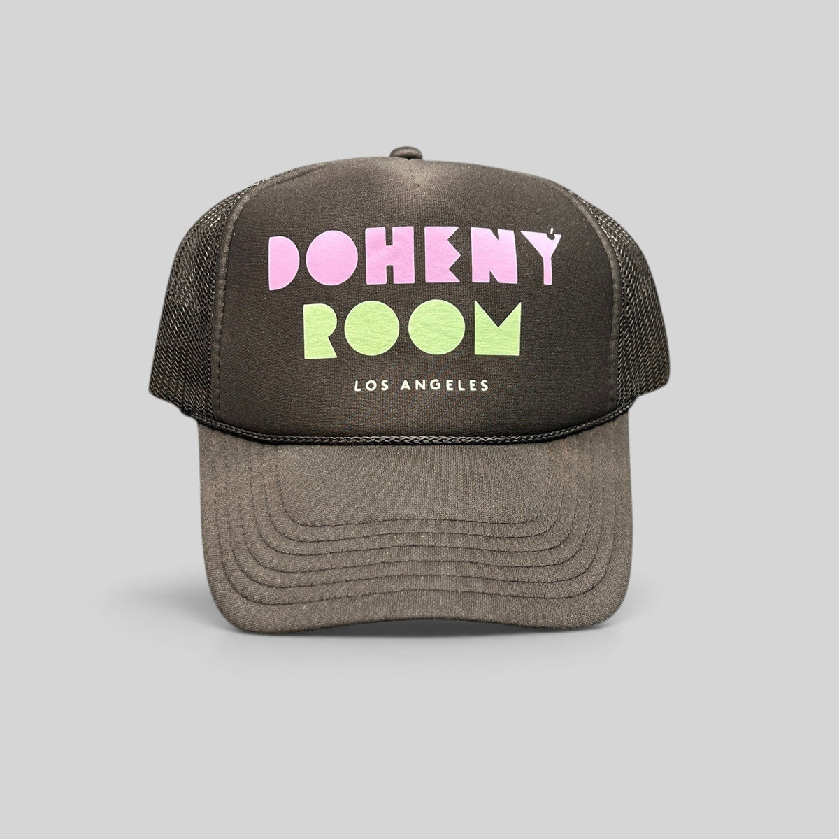 Raree Finds black mesh trucker hat with Doheny Room pastel logo on a structured foam front panel and curved brim.