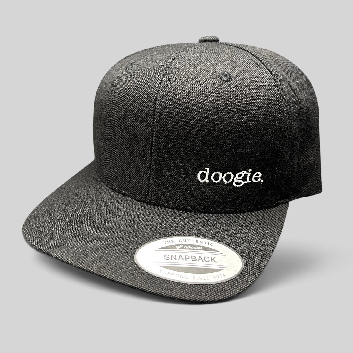 Raree Finds black Yupoong snapback hat with white embroidered doogie logo from the Doogie Kamealoha M.D. crew gift.