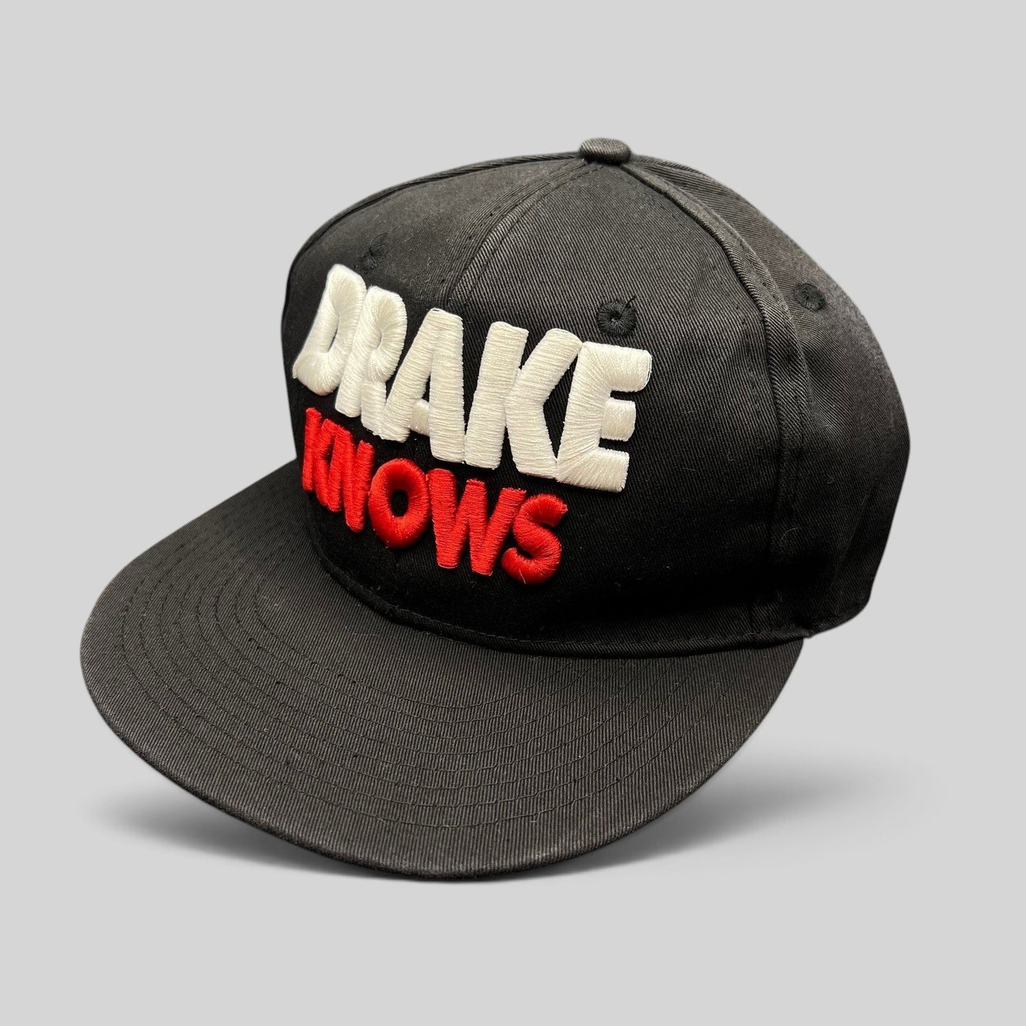 Raree Finds vintage black snapback hat with 3D embroidered white and red Drake Knows text on the front