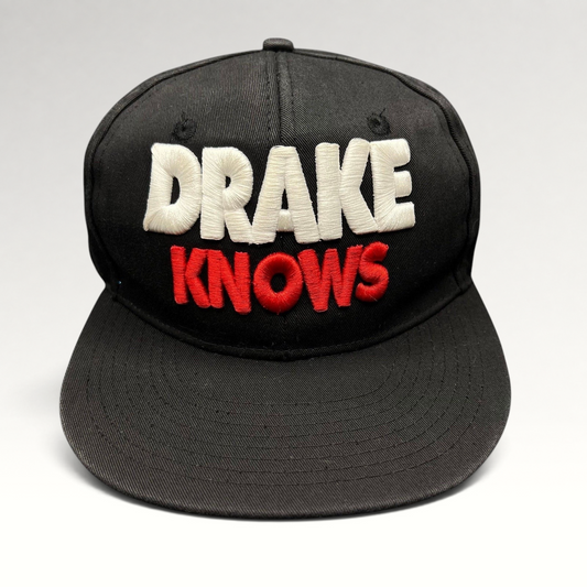 Raree Finds vintage black snapback hat with 3D embroidered white and red Drake Knows text on the front.