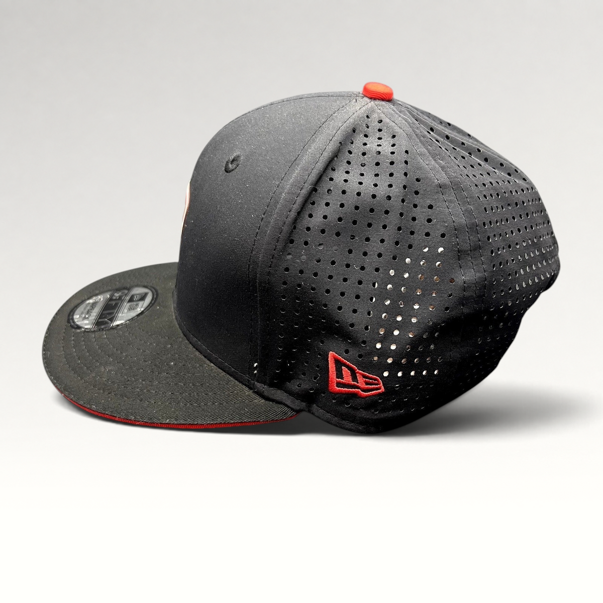 Raree Finds black New Era 9FIFTY Ducati snapback hat with laser-perforated side panels and red embroidered logo detail.