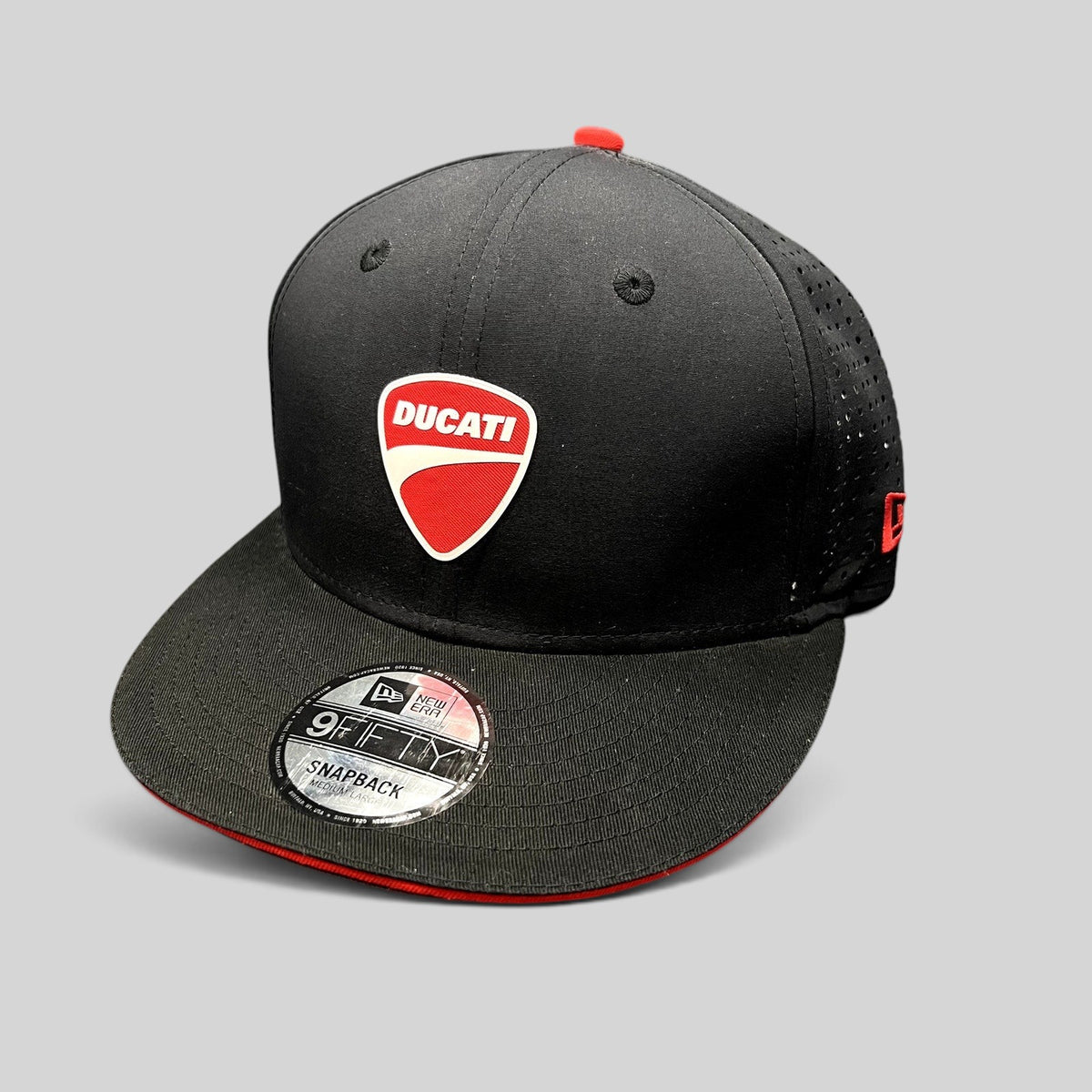 Raree Finds black New Era 9FIFTY Ducati snapback cap with red shield logo, flat brim, and perforated side panels.