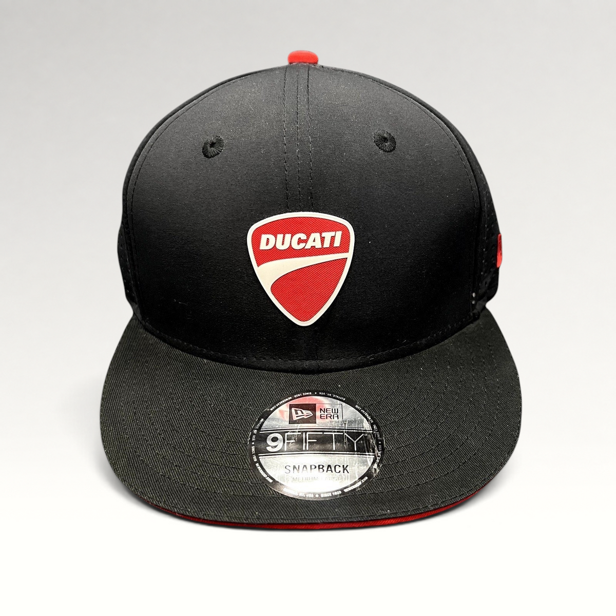 Raree Finds black New Era 9FIFTY Ducati snapback cap with a red shield logo and flat brim on a grey background