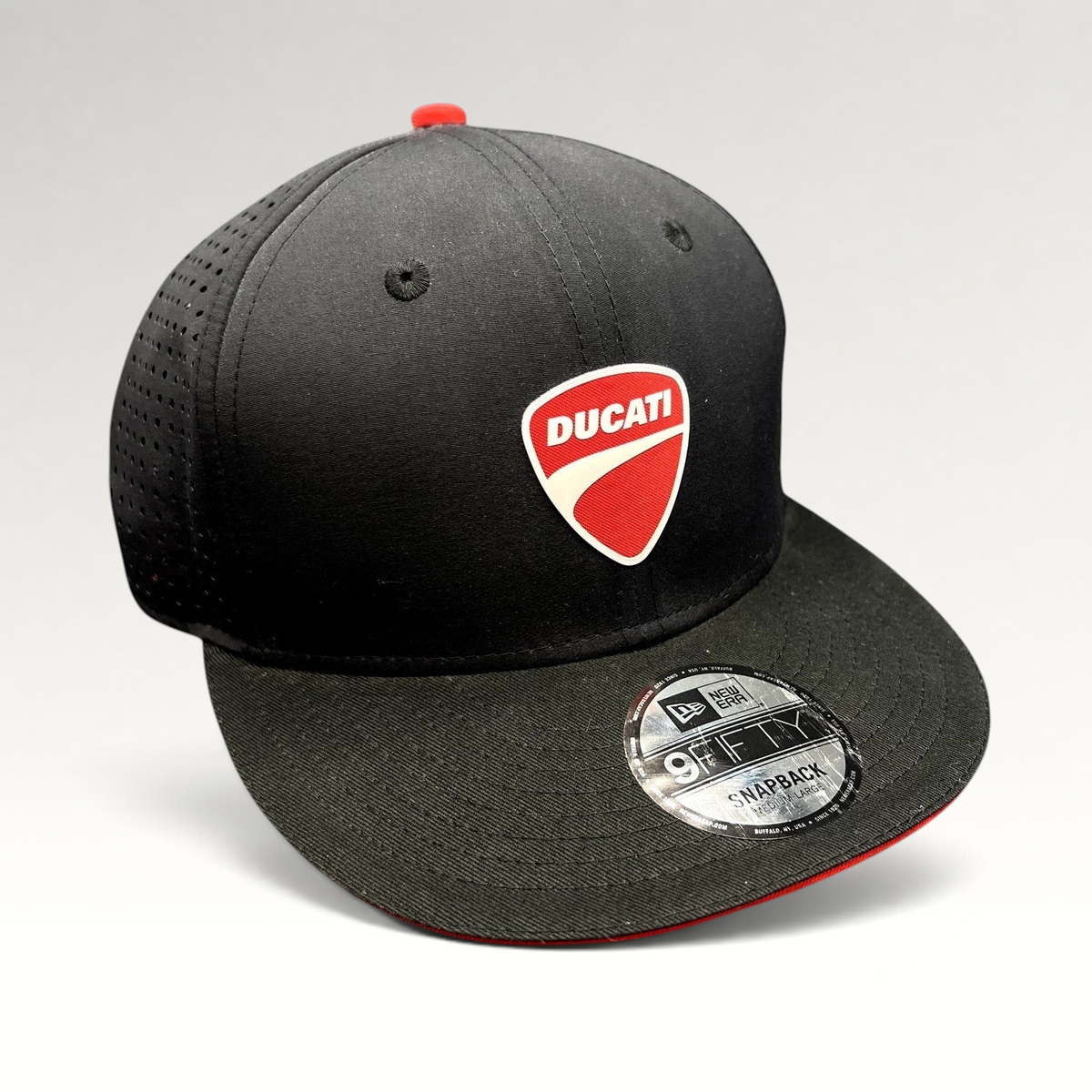 Raree Finds black New Era 9FIFTY Ducati snapback cap with a red shield logo, perforated panels, and flat brim.