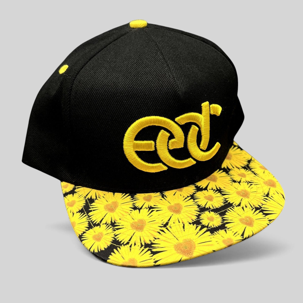 Raree Finds Insomniac EDC snapback hat with a black crown, yellow embroidered logo, and sunflower print flat brim.