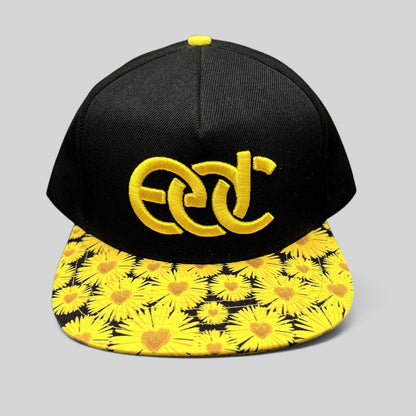 Raree Finds Insomniac EDC snapback hat with a black crown, yellow embroidered logo, and sunflower print flat brim.