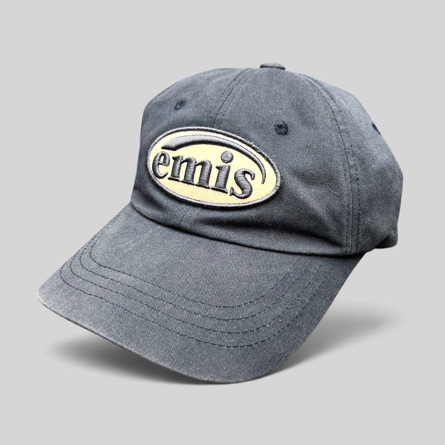 Raree Finds navy EMIS cotton strapback hat with a cream oval logo embroidery on the front and a curved brim.