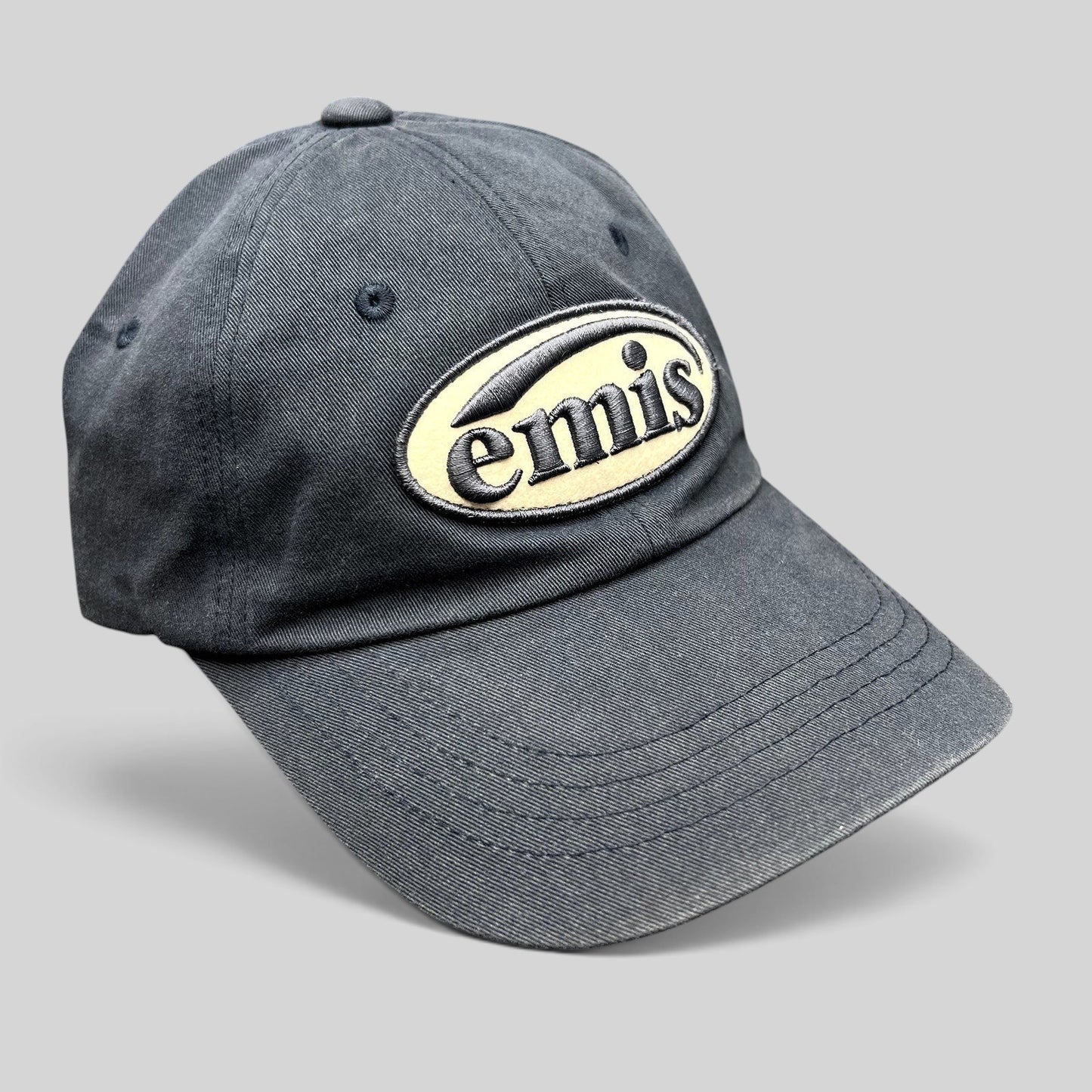 Raree Finds navy EMIS strapback hat with a cream oval logo embroidery on the front and a curved brim.
