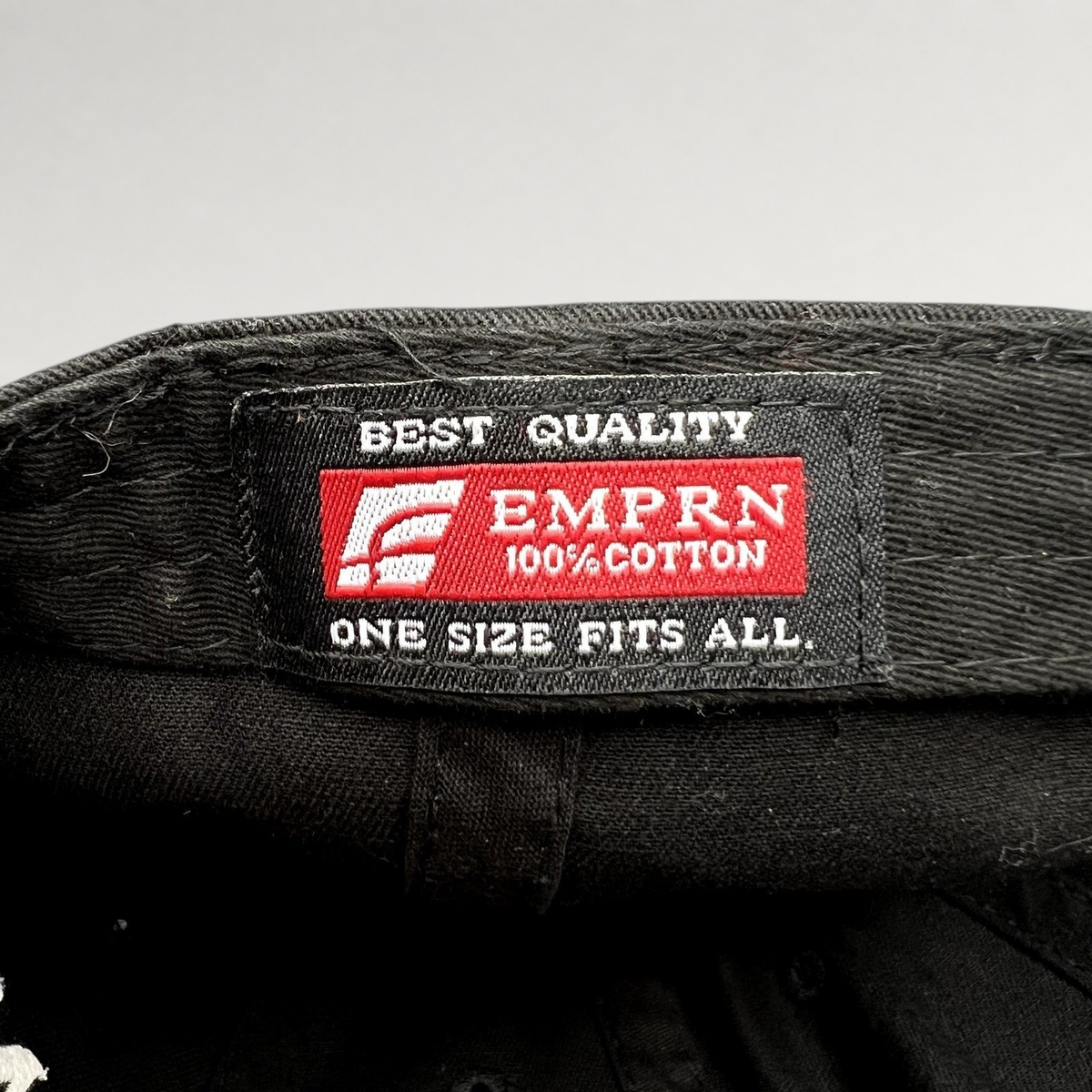Raree Finds black cotton strapback hat interior label featuring EMPRN branding and quality details