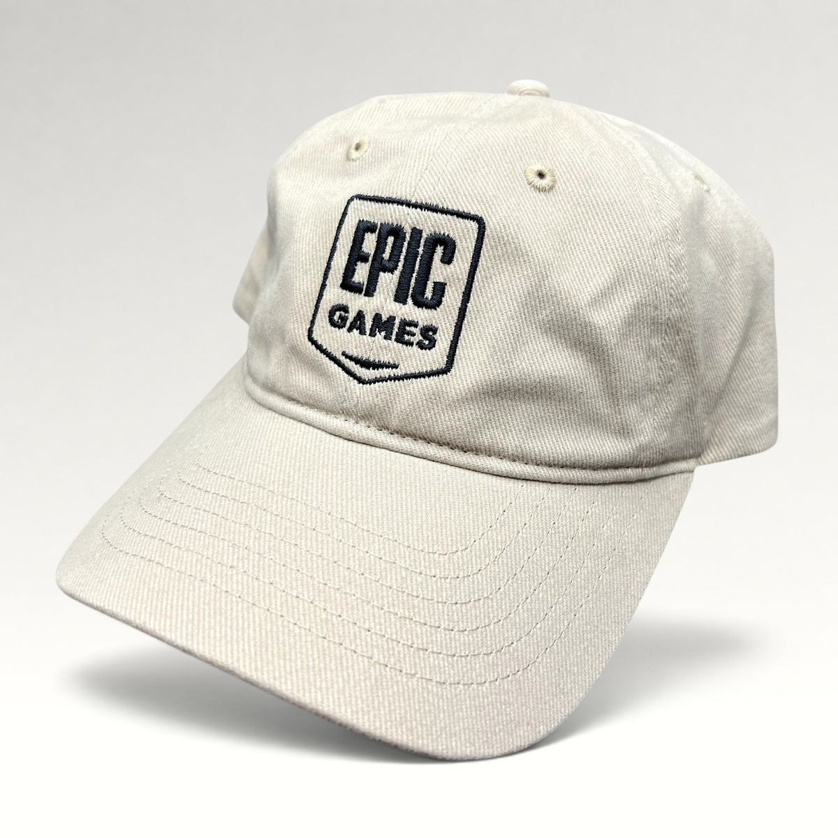 Raree Finds beige cotton twill dad cap with an embroidered Epic Games shield logo on the front and a curved brim.