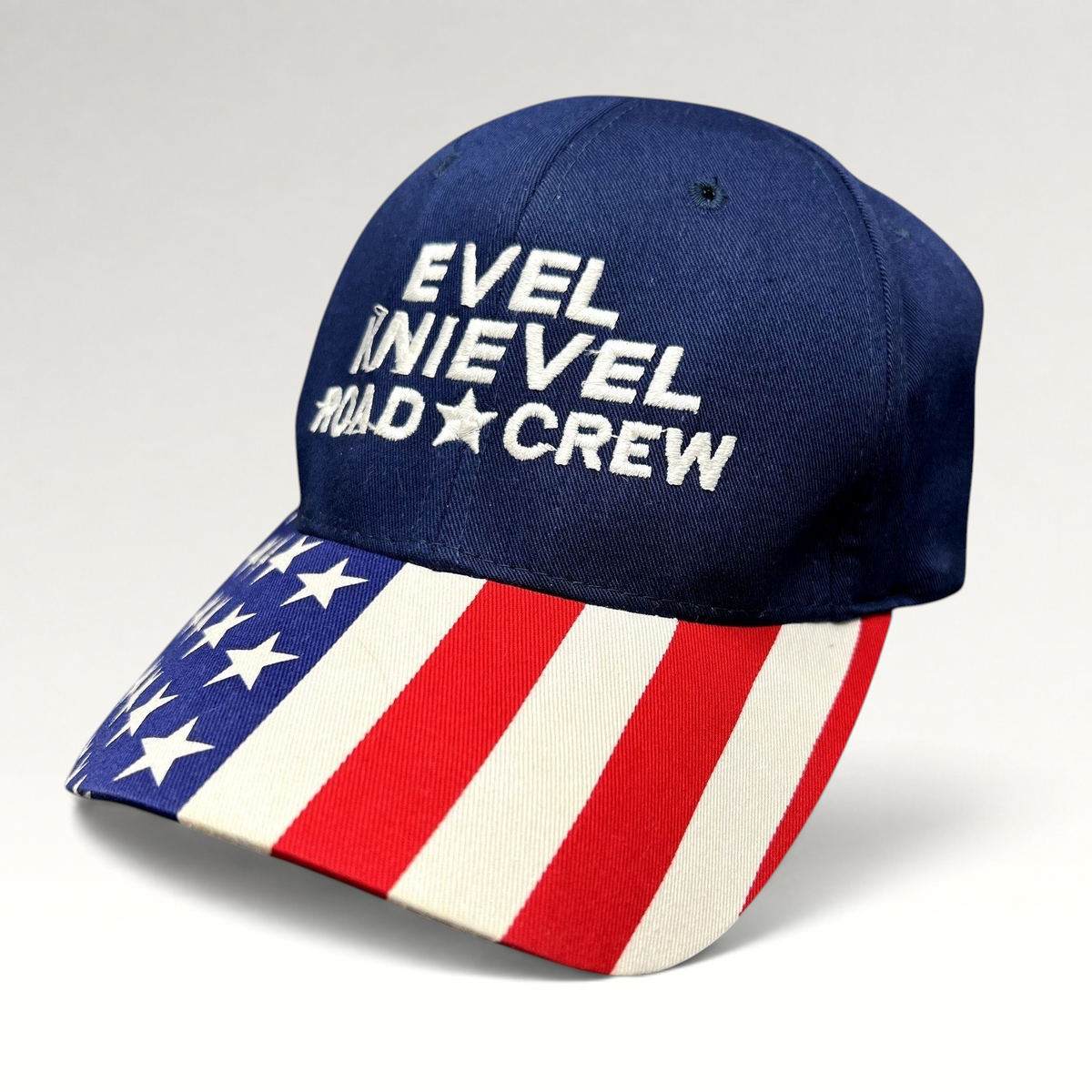 Raree Finds Y2K Evel Knievel Road Crew strapback hat with navy crown and patriotic American flag print curved brim.